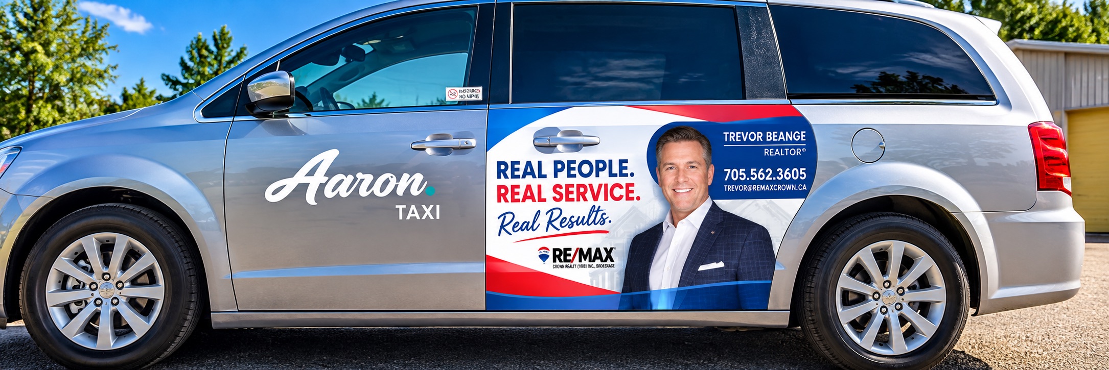 Silver taxi van with a branded realtor advertisement wrap